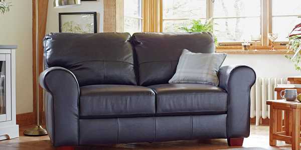 IMAGE ALT TEXT:  The black Habitat Salisbury 2-seater leather sofa in a country cottage style lounge